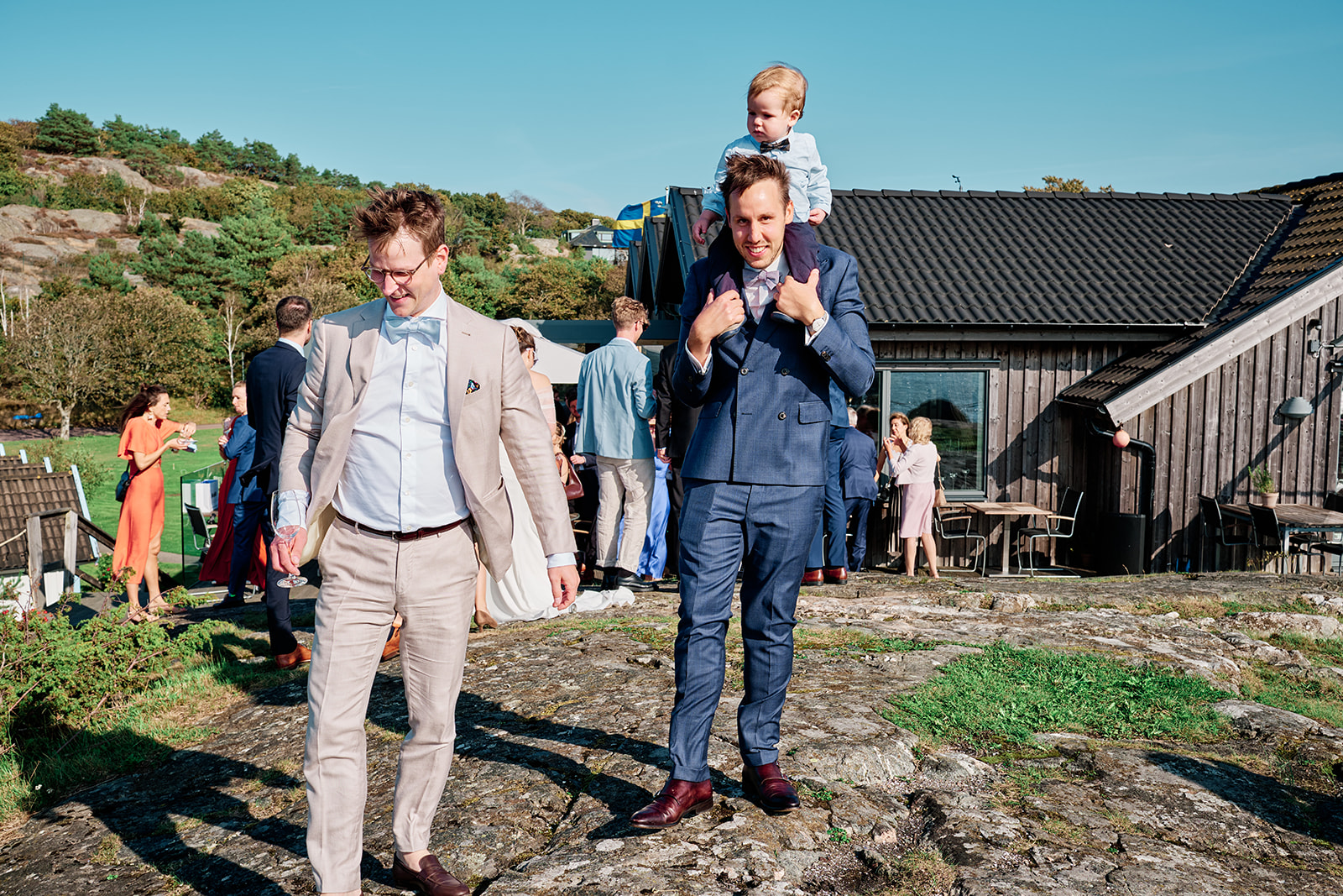 Guests walking up from the water, a child on his father shoulders