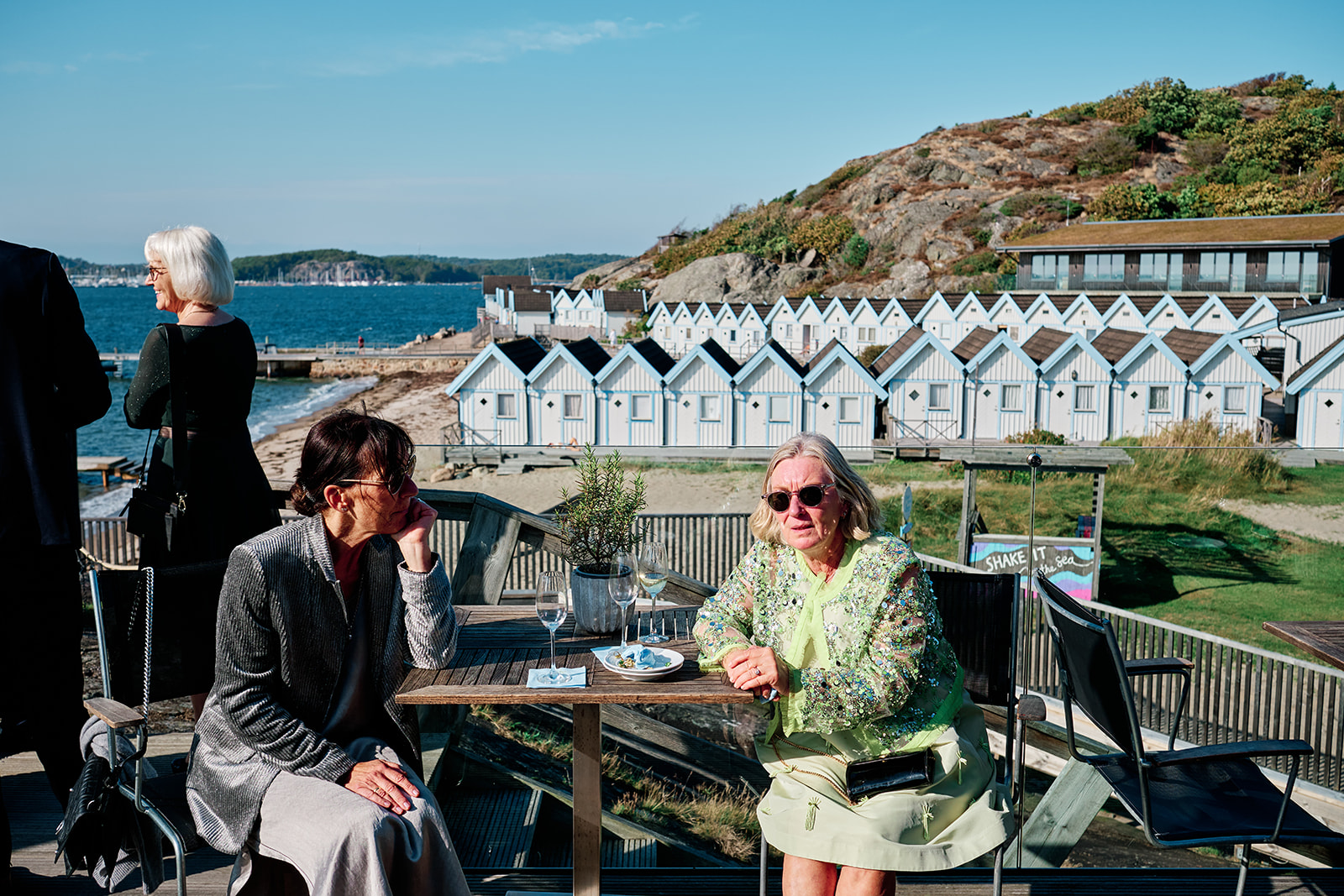 Guests at the terrace tables looking out over the bathing cabins