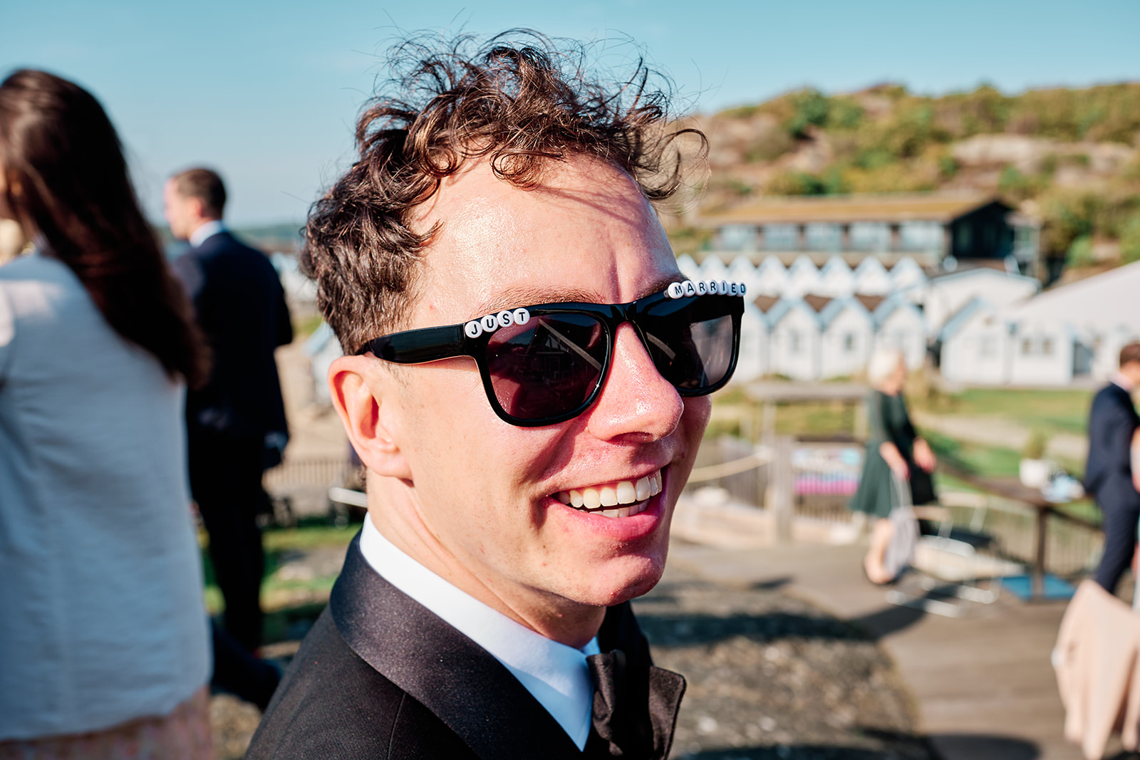 A guest laughing in sunglasses during the drinks reception