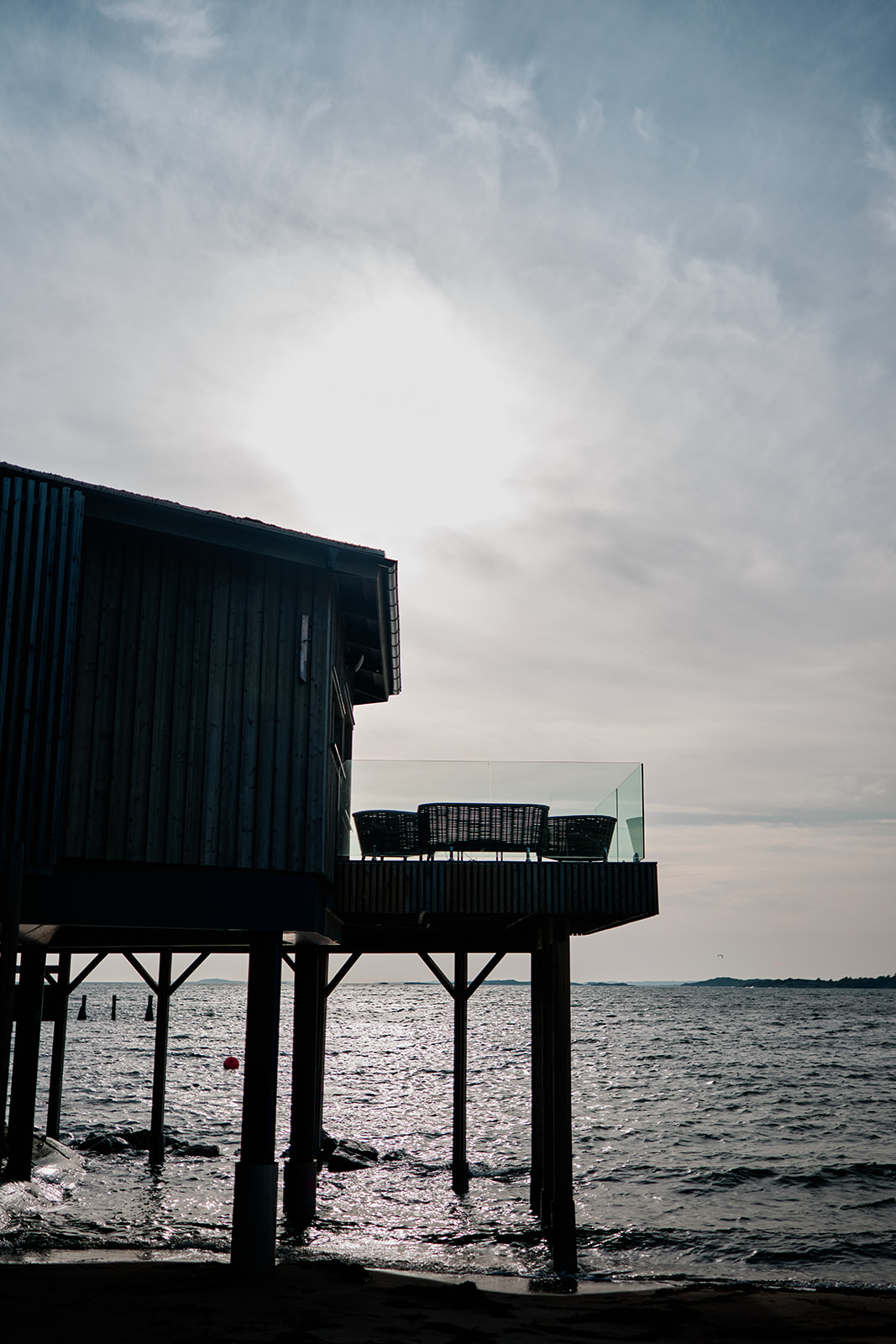The bathhouse standing out over the water, black and white
