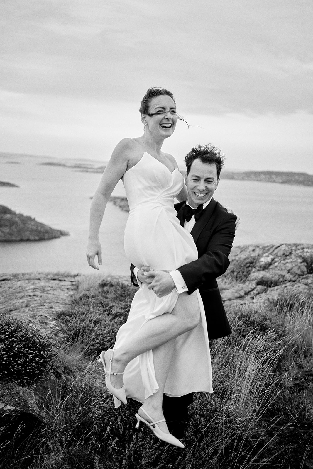 The groom carrying the bride on the archipelago rocks