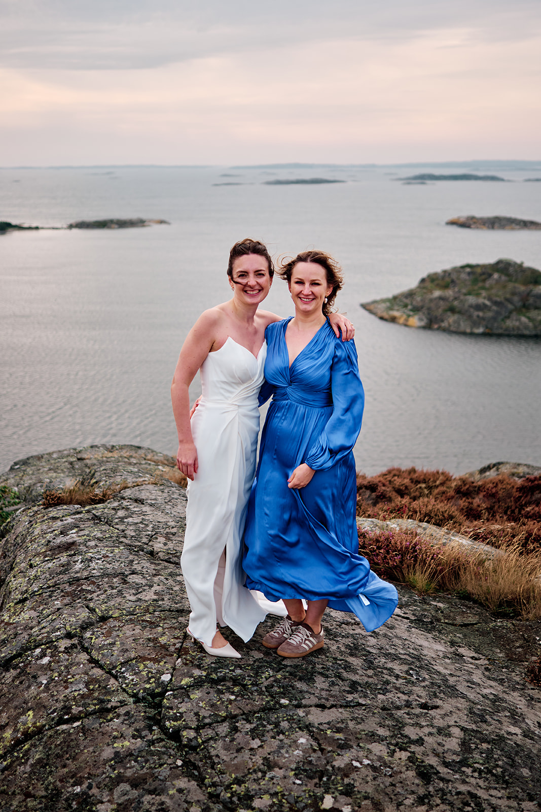 The bride with a guest in a blue dress by the sea