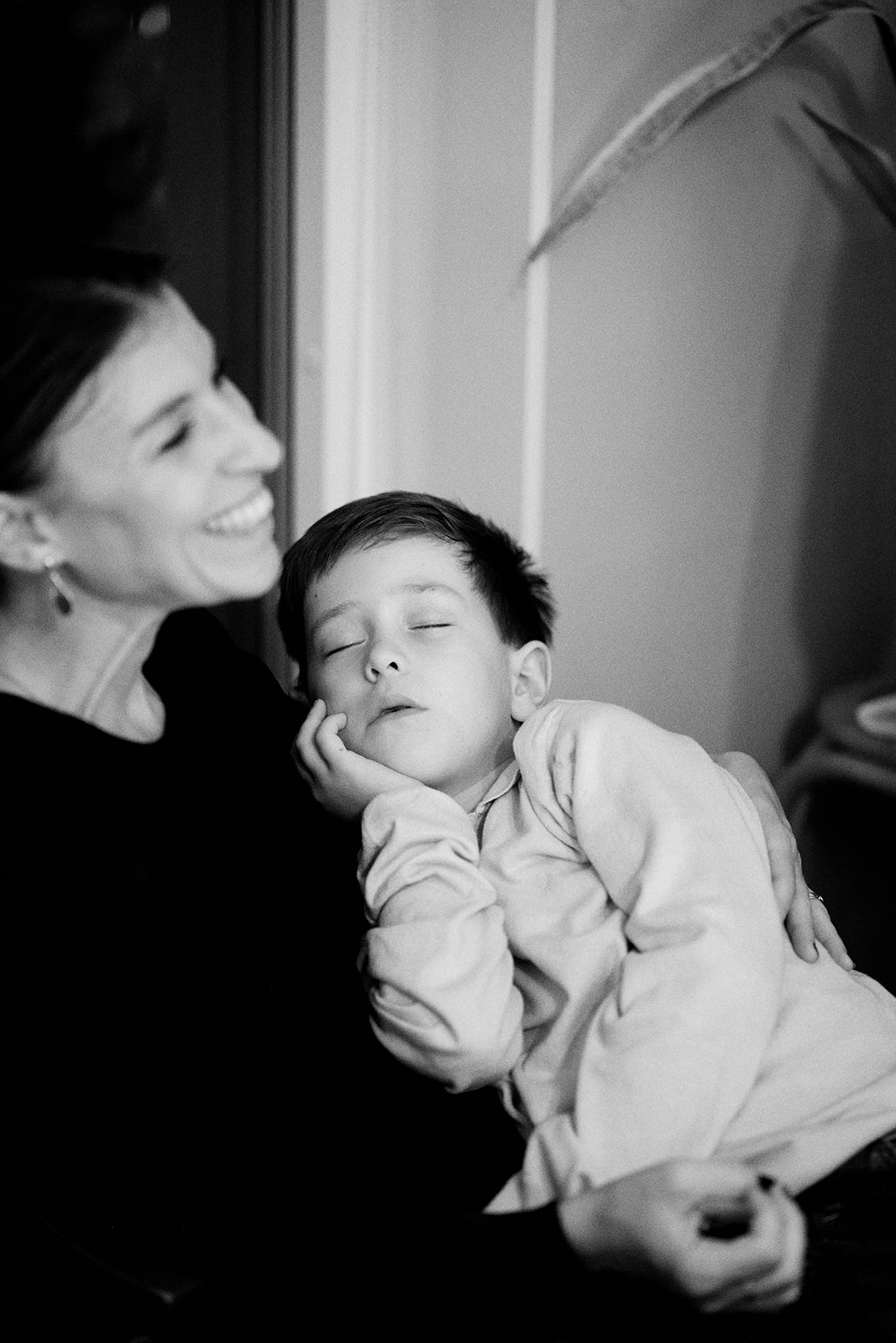 A boy asleep in his mother arms at the end of the night