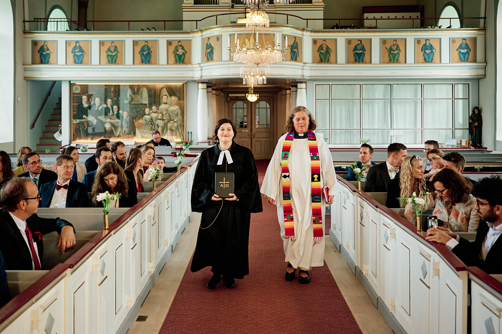 The officiant walking down the aisle at Sl&auml;ps kyrka